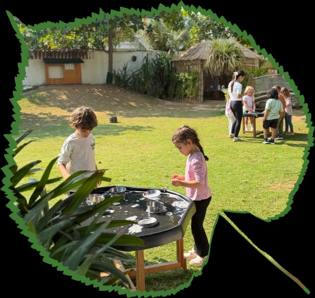 Children playing outdoors under a tree at Forest Oasis Nursery